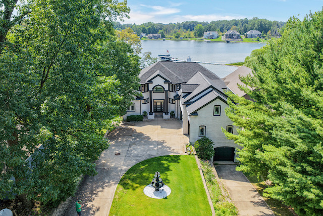 Aerial view of the estate's front elevation with its fountain courtyard, private drive and the lake beyond