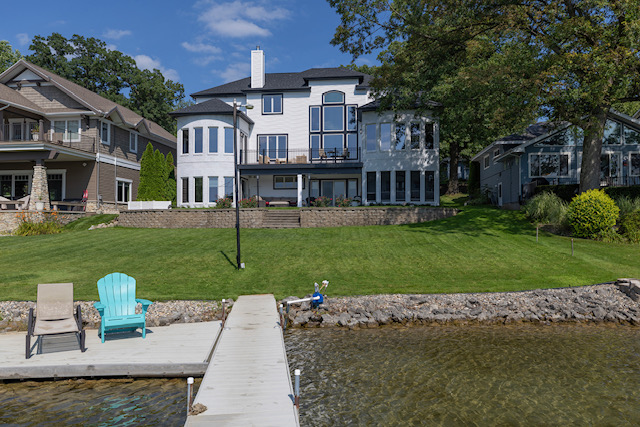 View from the private dock across the lawn to the lake-facing elevation of the estate